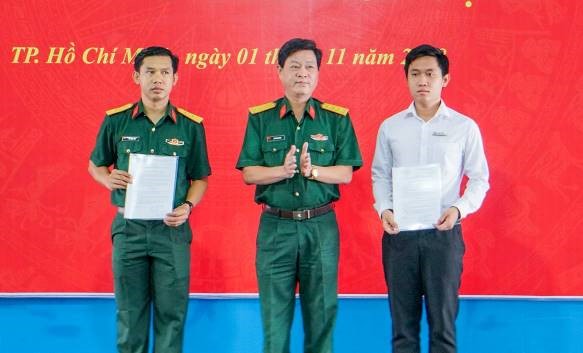 Thượng tá Lê Thanh Sơn, Quận ủy viên, Phó bí thư Đảng ủy quân sự, Chính trị viên BCHQS Quận 7 trao quyết định cho các đồng chí trong BCHQS TDTU