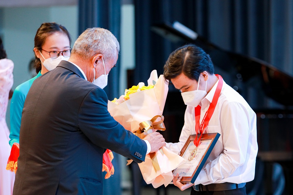 TS. Đặng Ngọc Tùng - Nguyên UV BCH Trung ương Đảng, Nguyên Chủ tịch Tổng Liên đoàn Lao động Việt Nam trao giấy khen và hoa cho tân sinh viên Khóa 25.