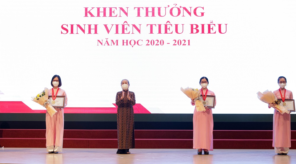 Cô Hoàng Thị Khánh - Chủ tịch Hội đồng sáng lập Đại học Tôn Đức Thắng trao giấy khen và hoa cho sinh viên có thành tích học tập - rèn luyện xuất sắc.  